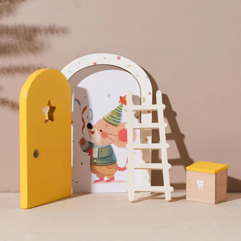 A yellow wooden door and a white ladder are displayed next to a small wooden tooth box against a neutral background.