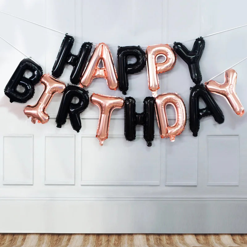 A decorative banner made of black and rose gold foil letters spelling out Happy Birthday