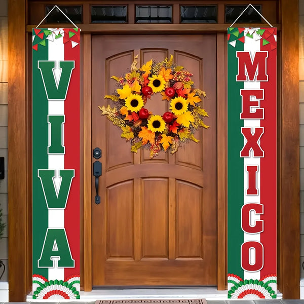 A wooden door decorated with a wreath and vertical banners featuring the words VIVA MEXICO
