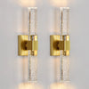 Modern bubble crystal LED wall sconces with brass accents mounted on a white wall.