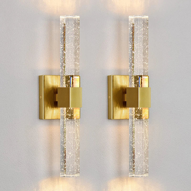 Modern bubble crystal LED wall sconces with brass accents mounted on a white wall.