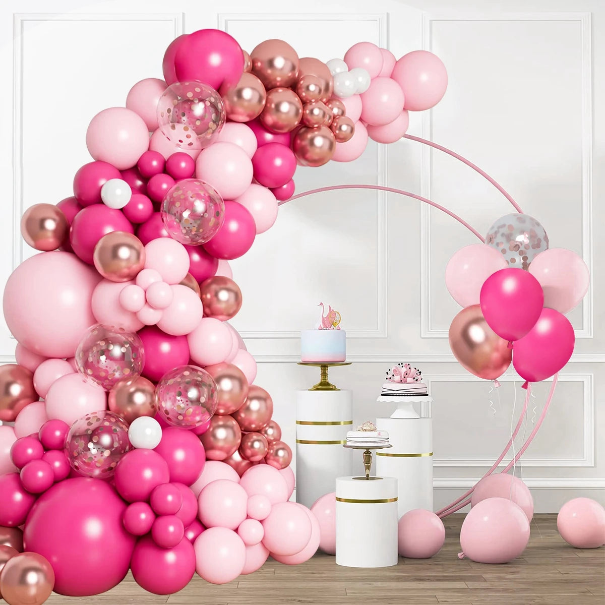 A large arrangement of pink and rose gold latex balloons with bows and ribbons displayed indoors.