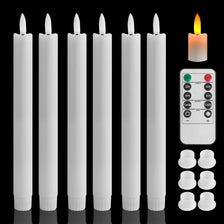 A set of six white flameless LED taper candles with black bases and an electronic control panel.