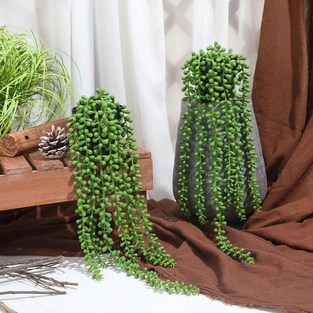 A potted hanging artificial plant wall decor with dense green foliage set against a white background.