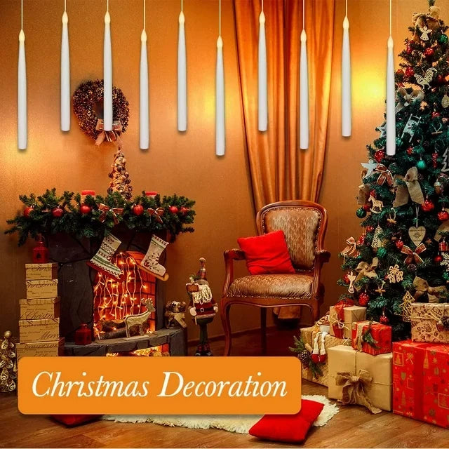 A festive Christmas decoration featuring tall white floating LED candles and a decorated Christmas tree.