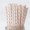 A vertical arrangement of white drinking straws with pink polka dots on a clear stand.