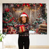 A woman in a black sweater poses in front of a Christmas woodland backdrop featuring decorated trees, gifts, and falling snow