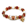 A stretch charm bracelet featuring round amber beads, white stones, and gold-toned charms.