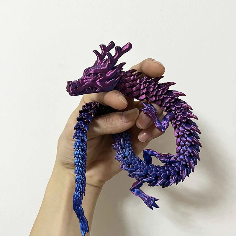 A hand holds a flexible, color-changing dragon figurine with purple and blue scales.
