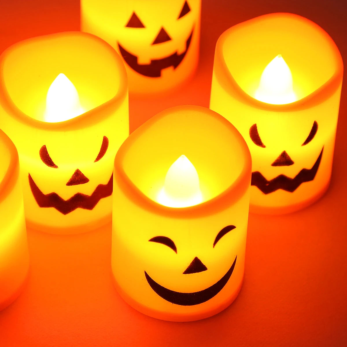 A set of six battery-powered LED Halloween candles with flickering flames glowing in orange light.