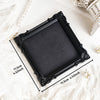 Black ornate picture frame with a dark mat and gold accents displayed on white fabric.