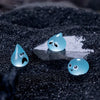 A set of eight glow-in-the-dark resin fairy water droplet figurines with various facial expressions resting on a dark surface