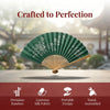 A green bamboo folding fan with intricate floral designs is displayed on a surface.