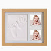 A wooden frame displaying a baby handprint and footprint keepsake inside.