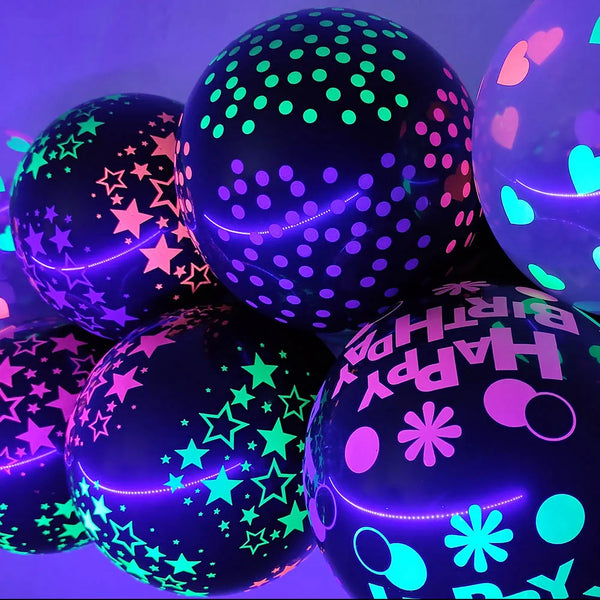 A close-up of several neon glow-in-the-dark latex balloons in purple and green with various confetti patterns.