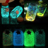 Various glass jars filled with glow-in-the-dark luminous pebbles used for garden and aquarium decor