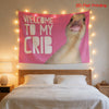 A pink tapestry featuring a duck's head welcoming guests to its crib, displayed above a bed.