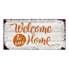 Rustic wooden hanging sign with orange script that reads Welcome to our home on a weathered white background
