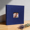 A navy blue linen front scrapbook memory book with a photo of a family inside.