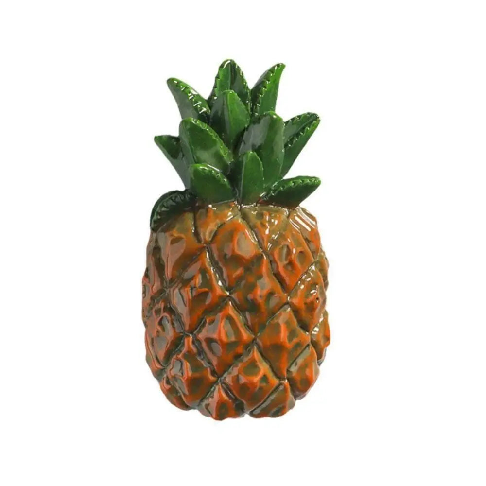 A realistic orange pineapple with a green leafy crown, used as a fridge magnet.