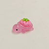 Pink resin charm shaped like a strawberry-covered turtle with green accents