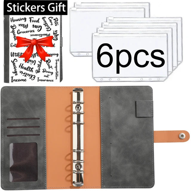 A set of six clear plastic stickers with text and a red ribbon on an orange leather planner binder.