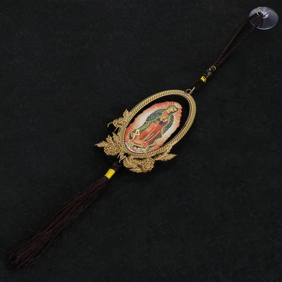 A wooden Our Lady of Guadalupe pendant with a gold frame and dark brown tassel.