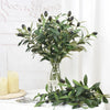 Artificial olive leaf branch with dark green leaves and small olive fruit on a glass stem