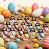 A collection of mini rubber Jesus figurines in various colors scattered on a surface for Easter and religious gifting.