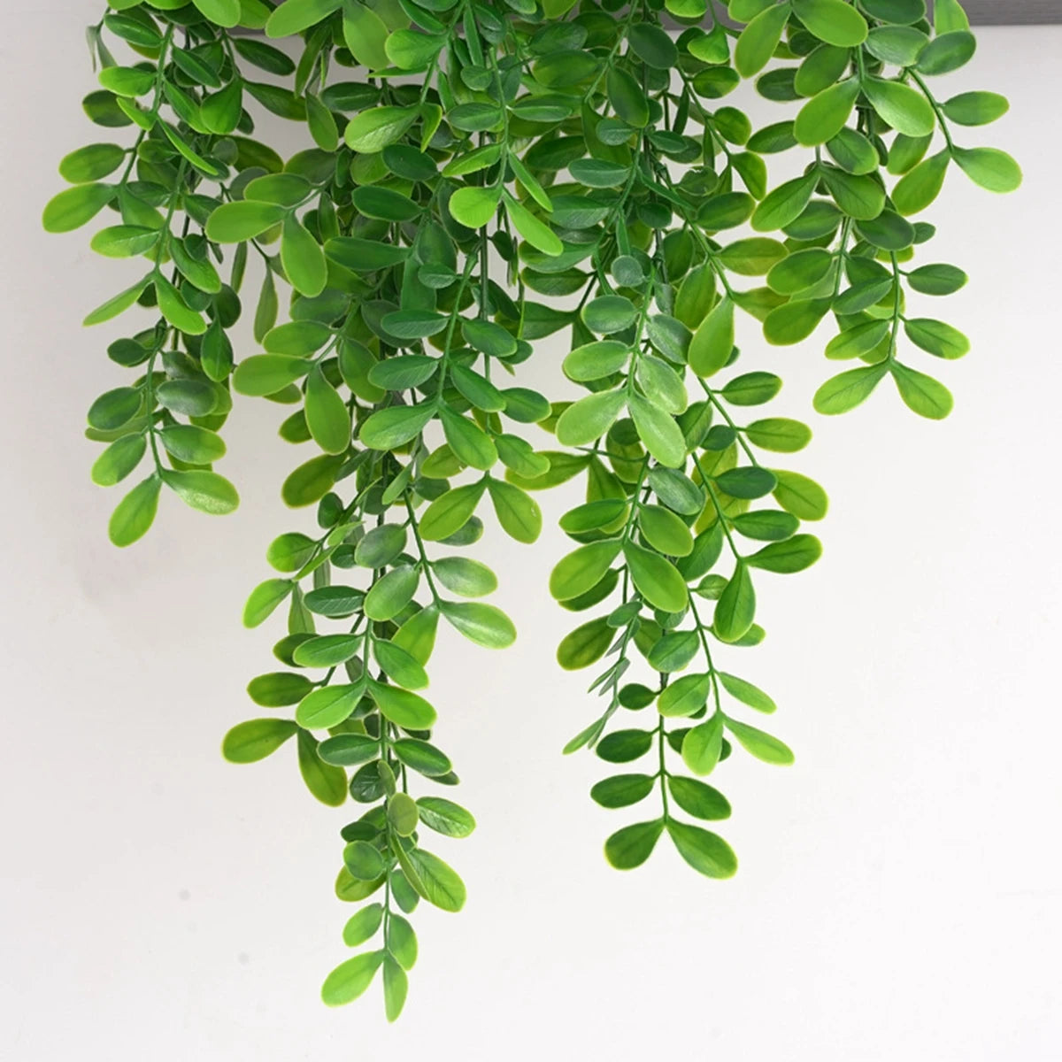 Green artificial ivy vine hanging down, used for home and garden decoration.