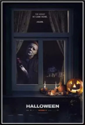 A dark window display featuring a horror movie scene, candles, and a carved pumpkin for Halloween wall art.
