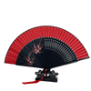 A red and black elegant bamboo folding fan with delicate floral designs shown open.