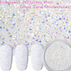 A collection of iridescent glass sand rhinestones and white glitter nail art materials are shown.