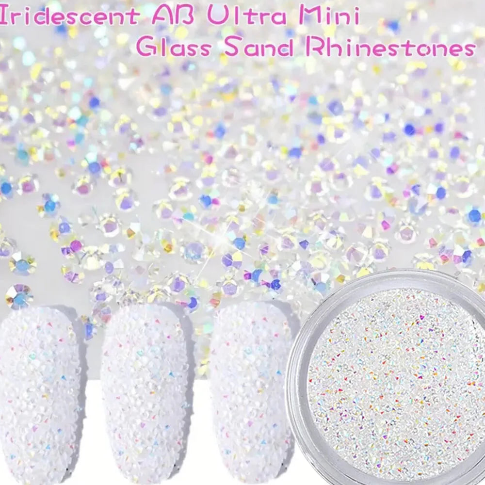 A collection of iridescent glass sand rhinestones and white glitter nail art materials are shown.