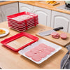A stack of red reusable food preservation trays and a pink tray are displayed on a wooden cutting board.
