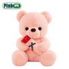 A pink teddy bear plush toy holding a red fabric flower