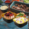 A set of reusable aluminum foil baking cups with lids and spoons containing food items like chocolate cake and meat.