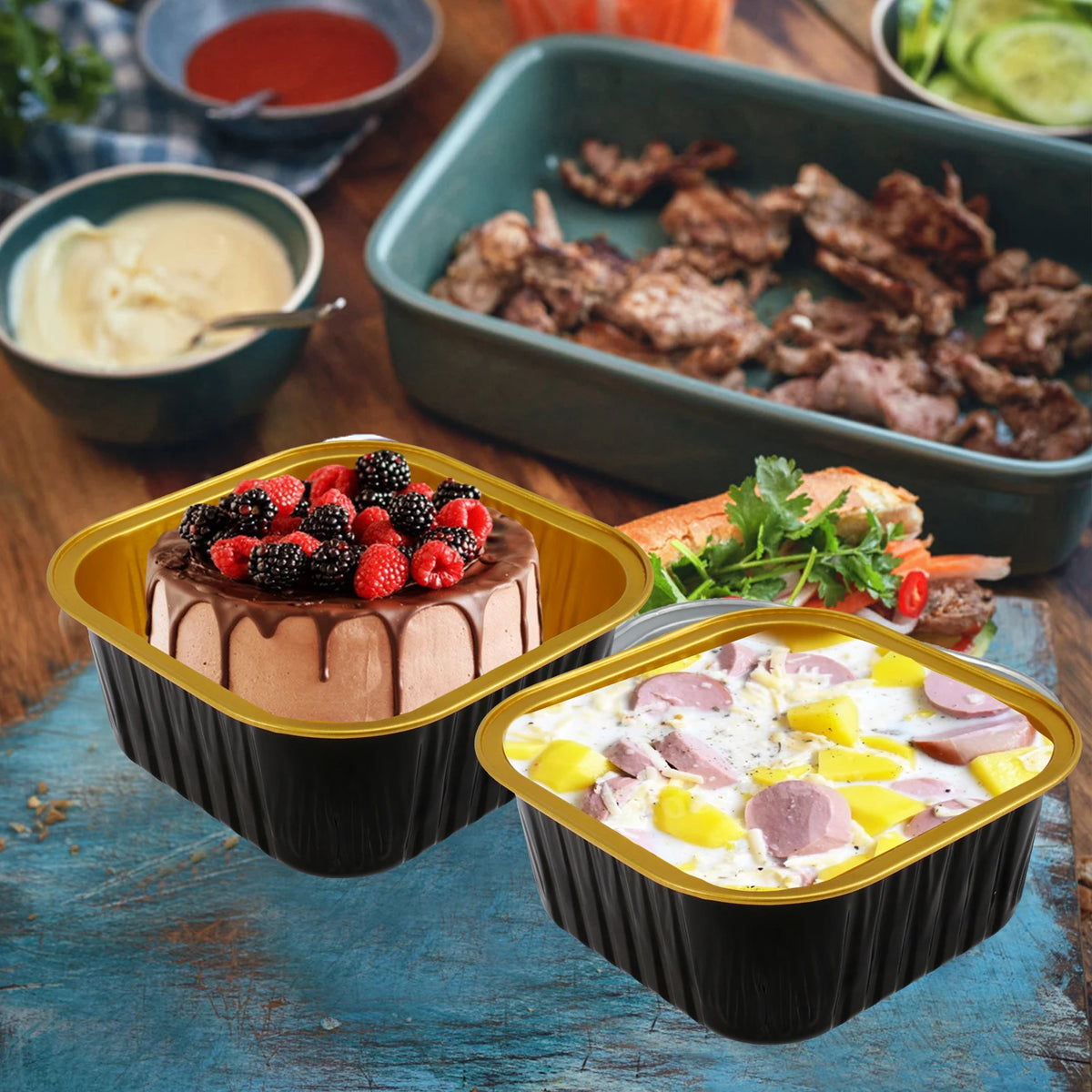 A set of reusable aluminum foil baking cups with lids and spoons containing food items like chocolate cake and meat.