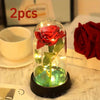 Ein Glasgefäß mit einer leuchtend roten Rosen-LED-Dekoration auf einer schwarzen Basis.
