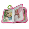 A pink and white striped cloth baby photo album with a green loop closure displaying photos of babies.
