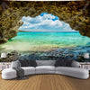 A scenic backdrop featuring a turquoise ocean view framed by natural rock formations and clouds.