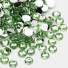 A scattered pile of round flatback resin rhinestones in various shades of green and clear white.