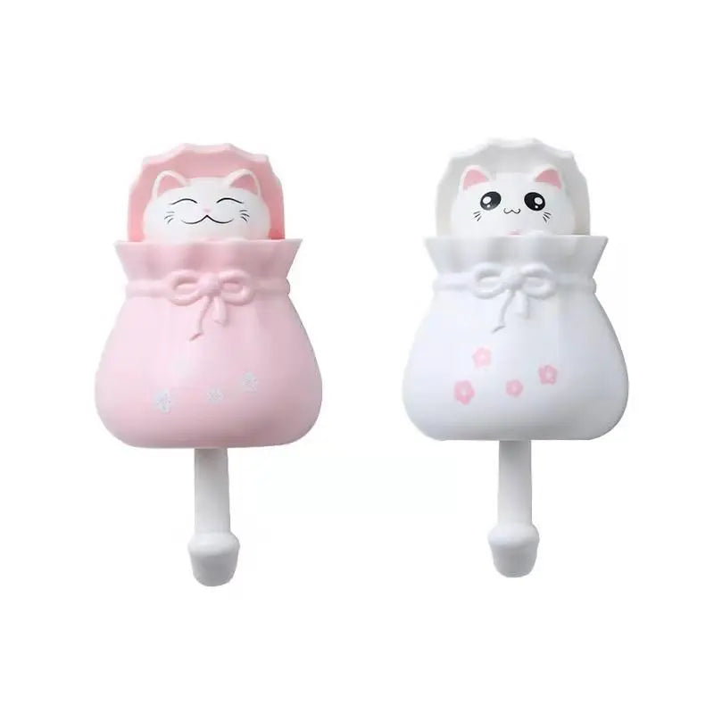 A pair of pink and white cartoon cat wall hooks for organization, featuring cute cat faces.
