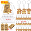 A collection of cute bear keychains, thank you tags, and organza bags for party favors.