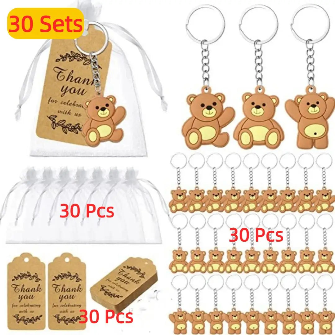 A collection of cute bear keychains, thank you tags, and organza bags for party favors.