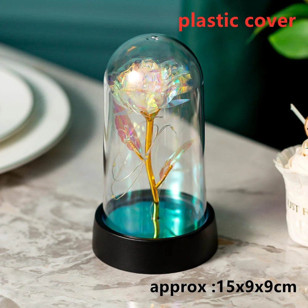An LED galaxy rose artificial flower displayed in a glass dome on a black base.