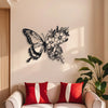 Black metal butterfly wall decor featuring an intricate floral pattern on a light-colored wall.