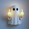 A white ghost figurine lamp with a warm glow, making a finger gesture.