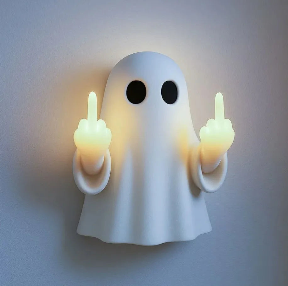 A white ghost figurine lamp with a warm glow, making a finger gesture.