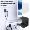 A black multi-functional headphone storage bracket mounted on a white wall, showing its use for hanging headphones.